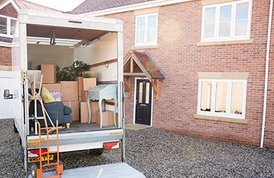 moving truck loaded with boxes parked in front of a house with ten items ready for relocation
