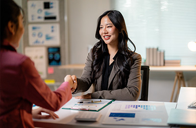 business professionals shaking hands in office setting presenting five key strategies and analyzing growth data